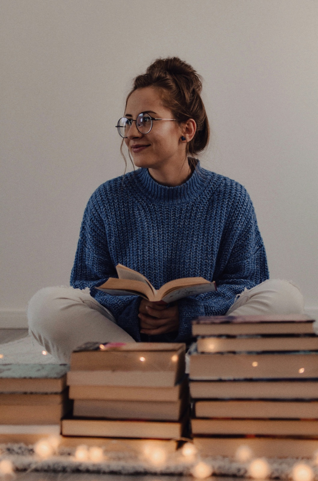 A reader, hands resting in lap, holding an open book.